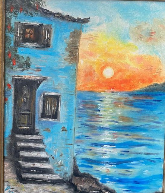 A blue seaside house with stone steps at sunset
